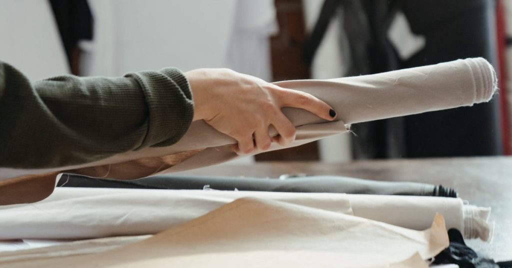 Woman cutting roll of fabric | Eco Friendly Fabrics | How to build a green wardrobe tips | How to choose ethical and sustainable materials