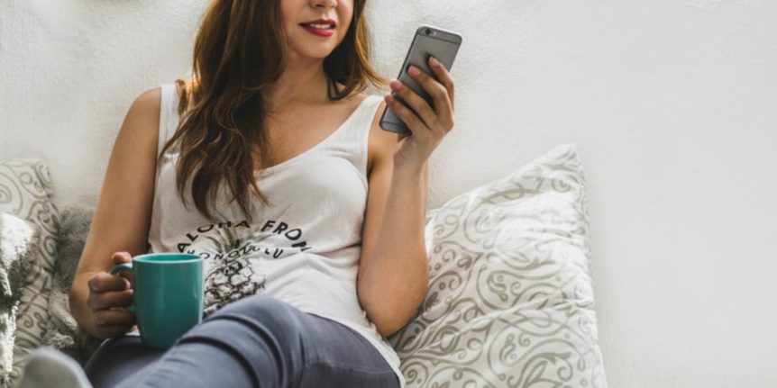 Woman scrolling on smartphone | 3 of the best clothes swapping app in the uk | preloved clothing tip