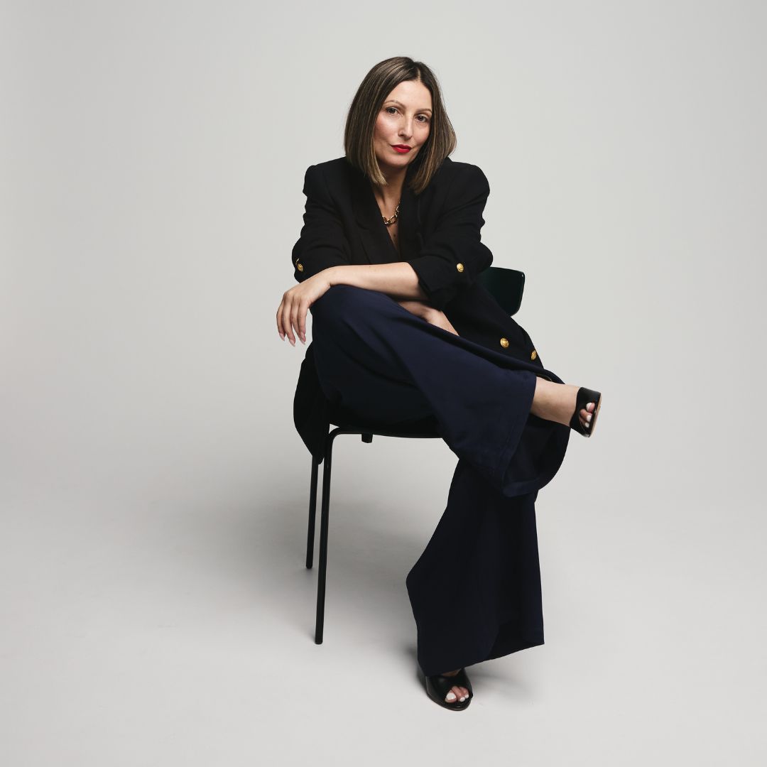 About Roberta Lee - London based Luxury Sustainable Stylist sits elegantly on a chair.
