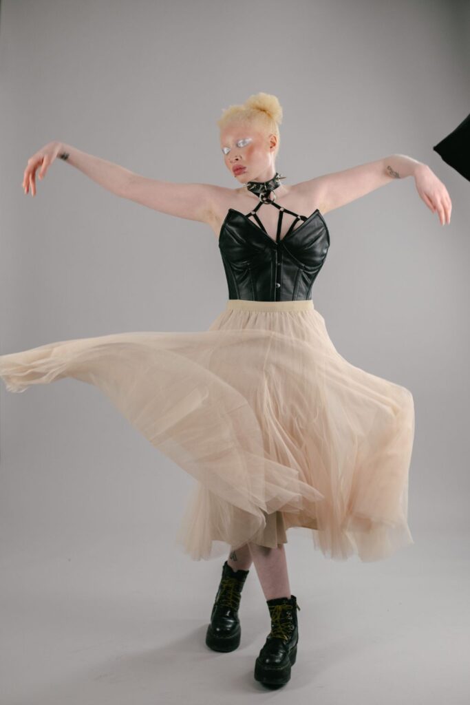 Nan a model for Zededee wears a black corset and cream tulle skirt with chunky boots 