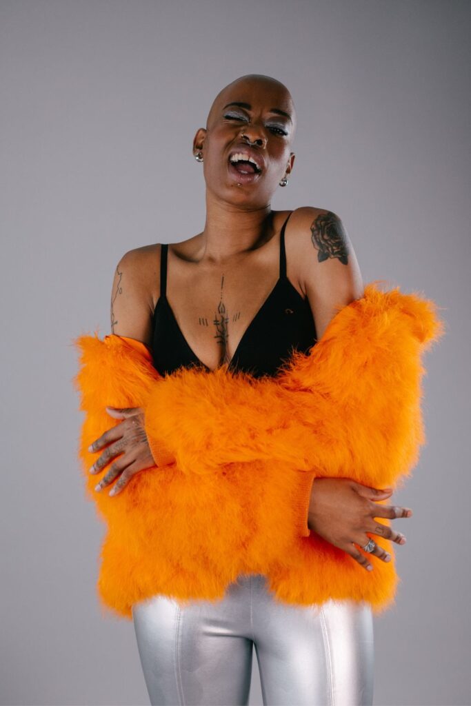 New upcoming model Ade from Zebedee wears orange jacket and black bra
