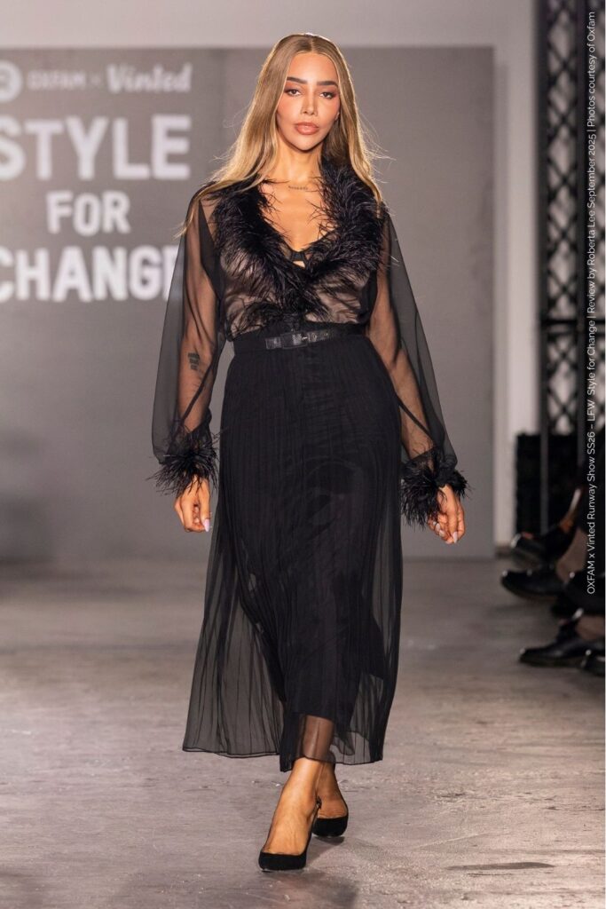 Munroe Bergdorf in black sheer-sleeved maxi dress with feather v-neck and sleeve detail – Oxfam Runway Show London Fashion Week SS26