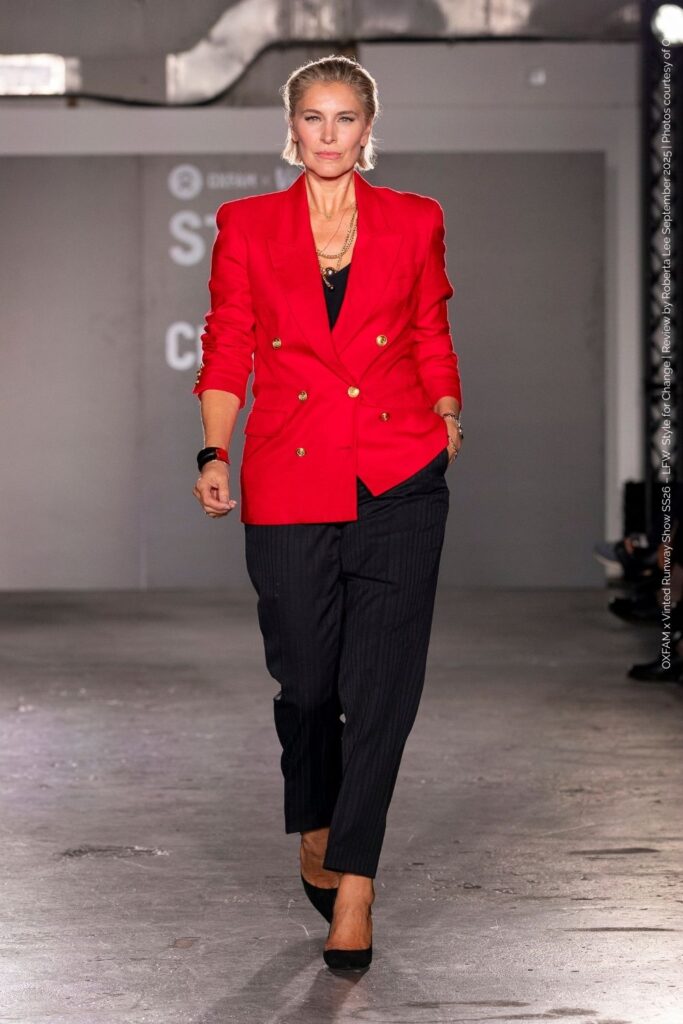 Louise Boyce in preloved bold red 80s power jacket with black trousers and pointed shoes – Secondhand Runway Show at London Fashion Week.