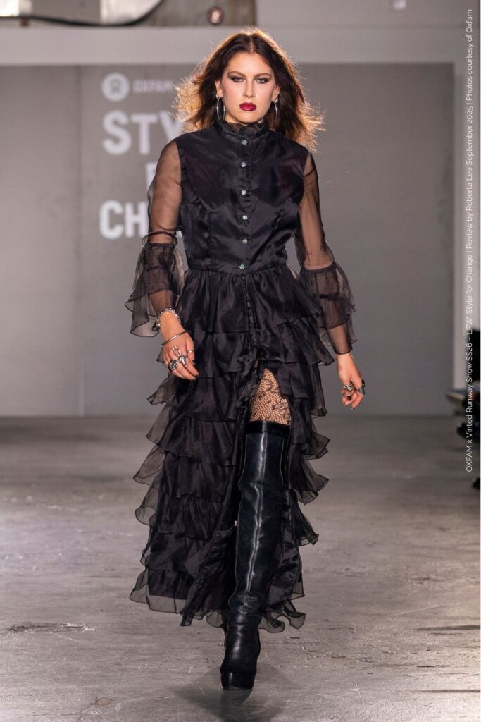 Gracie Emery in black frilled dress with thigh-high boots at the Oxfam x Vinted Style for Change Runway Show SS26.